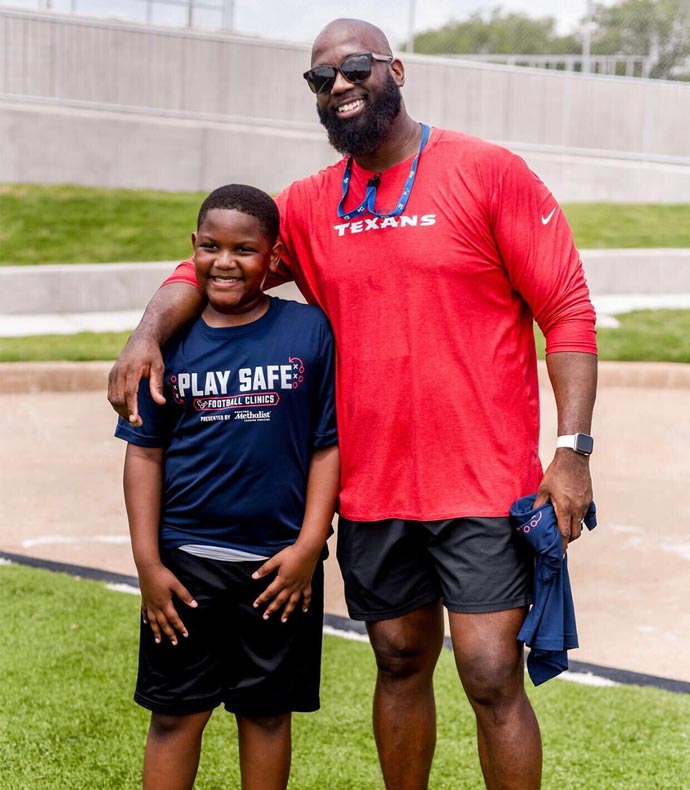 coach-cam-cameron-campbell-with-child-at-texans-play-safe-event